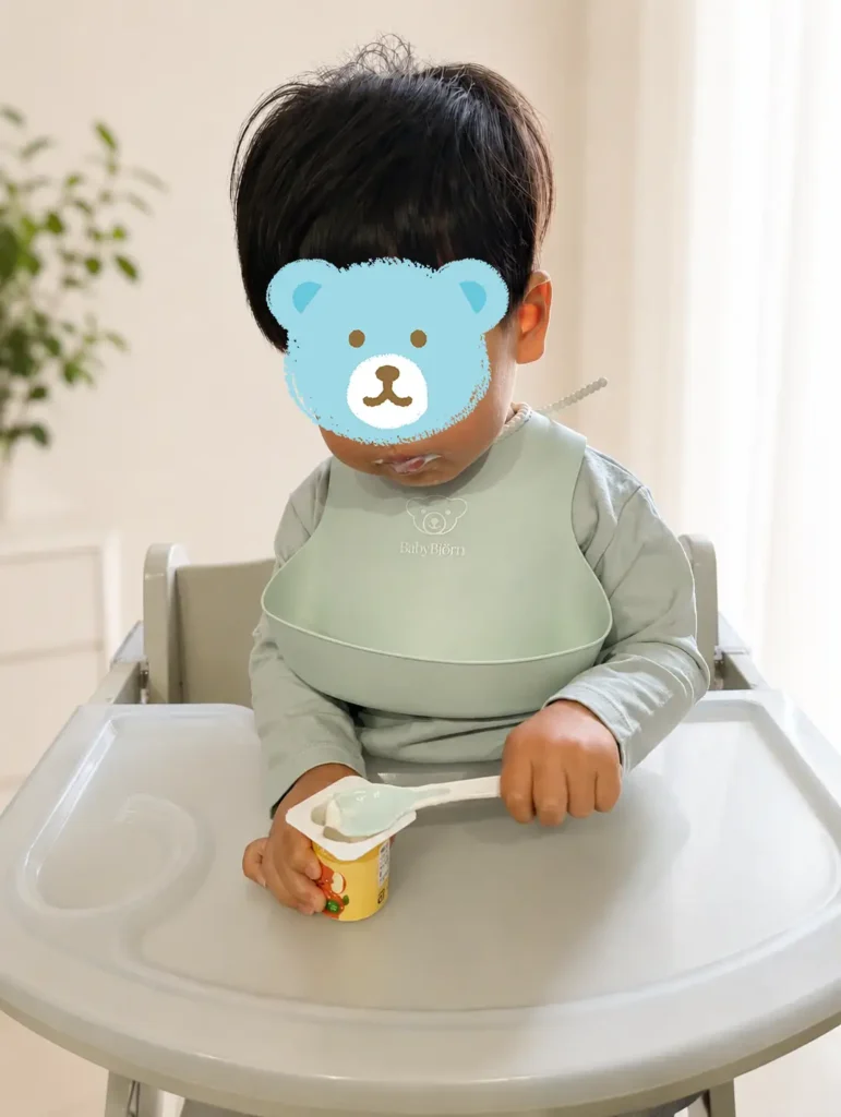 BabyBjörnのシリコンビブをつけて食事中のわが子